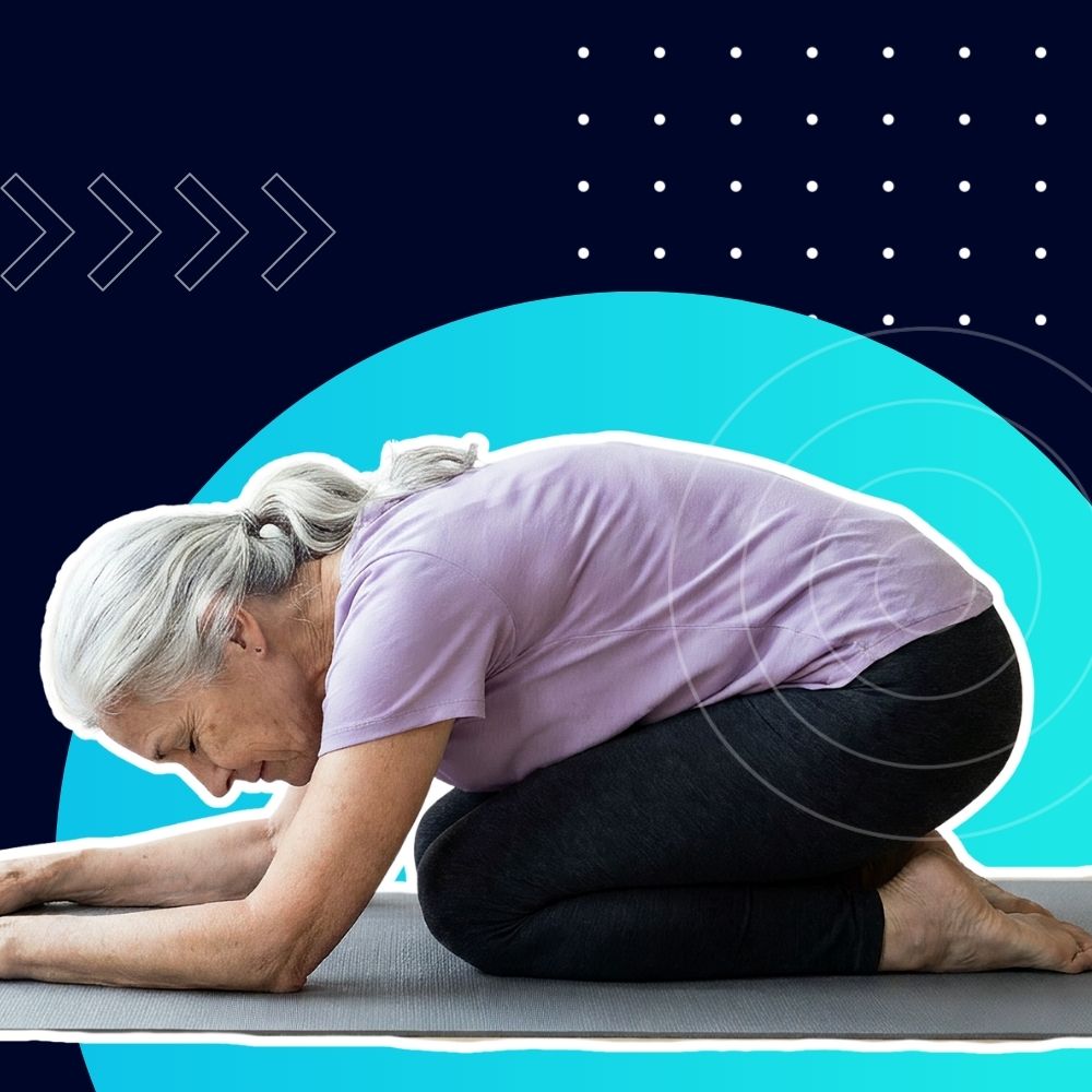 Older woman in a purple top kneels forward on a yoga mat in Child's Pose for a gentle stretch